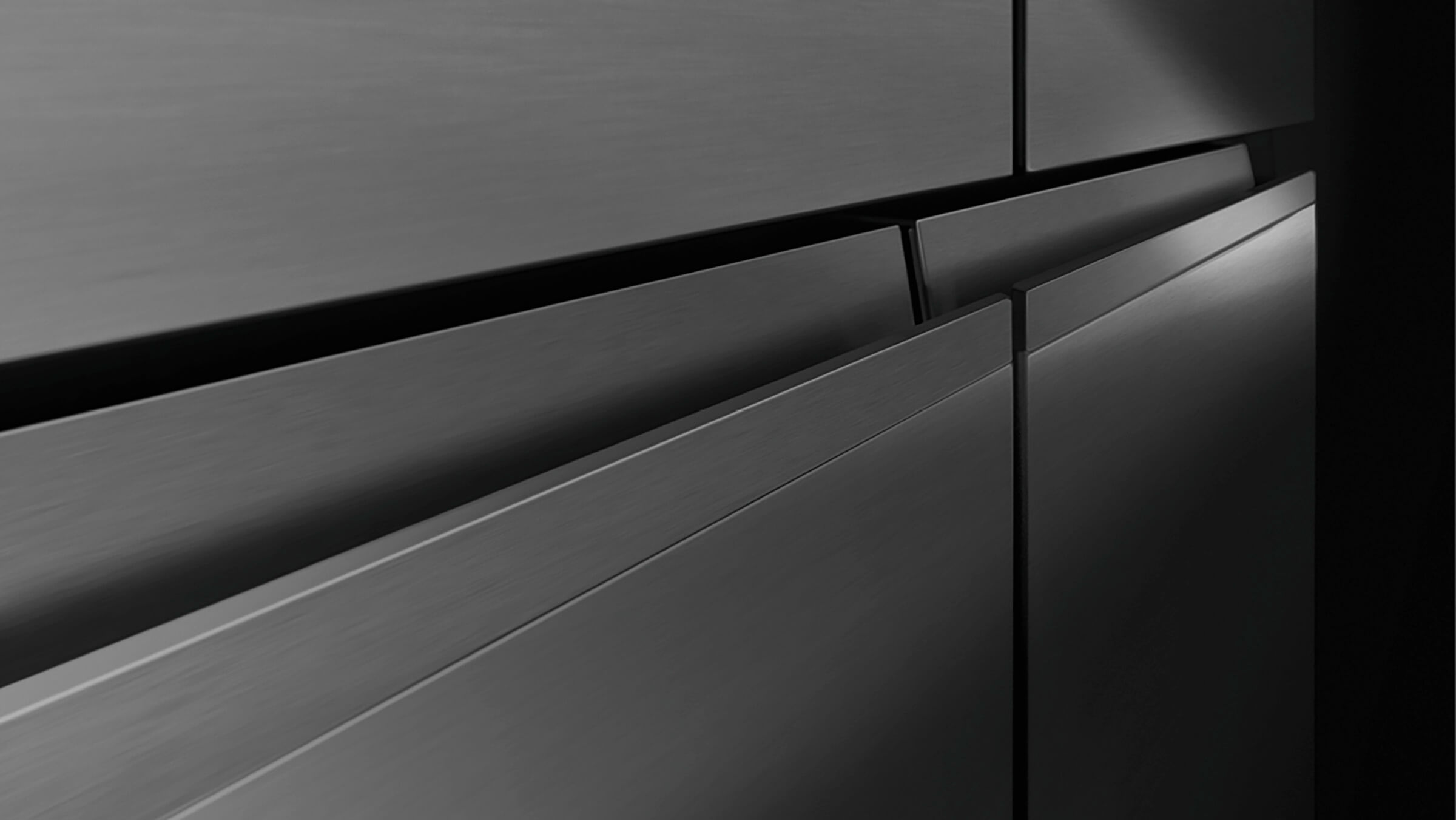 A black stainless steel Quad Door refrigerator with recessed handles, designed for effortless use
