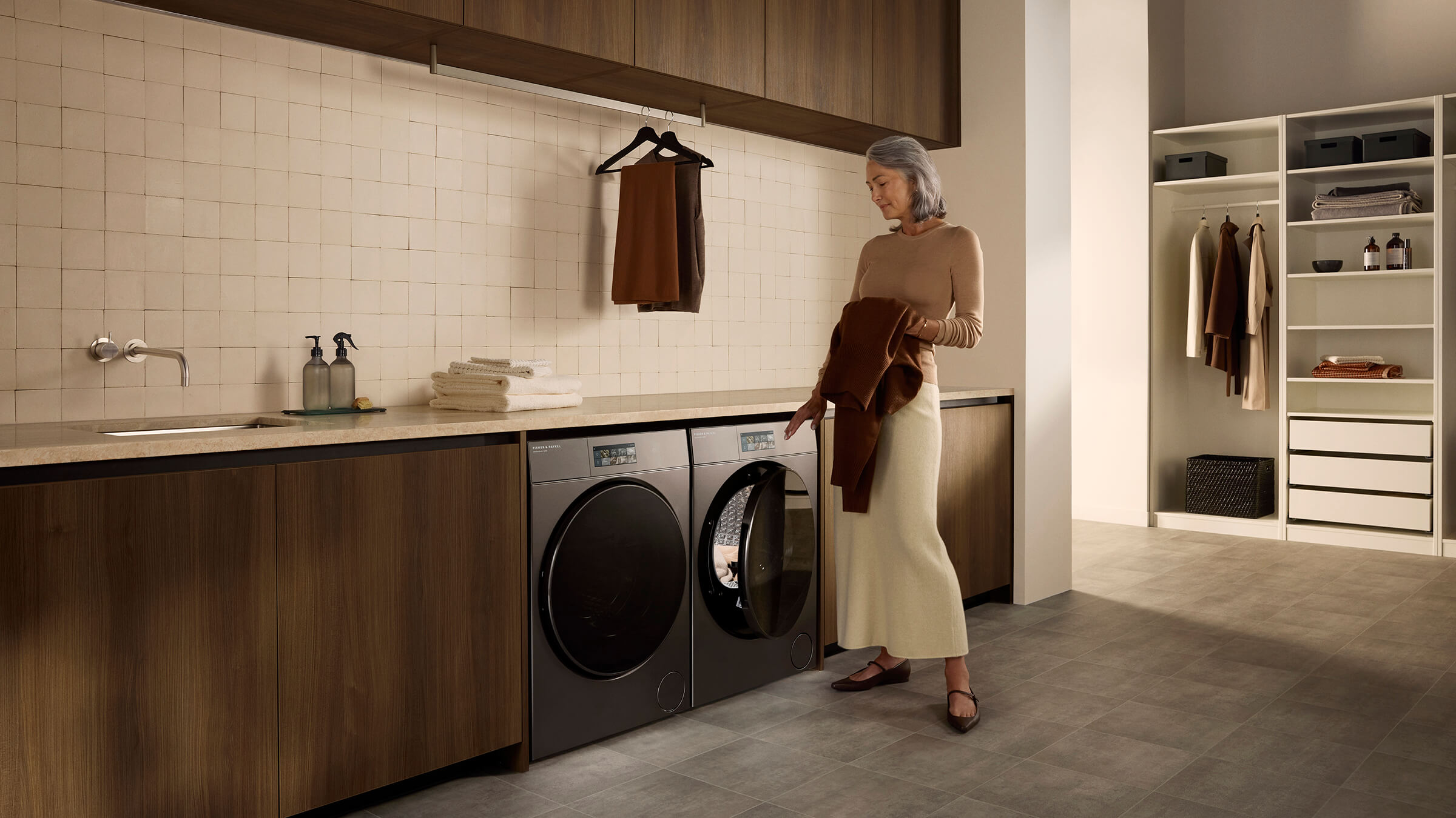 Women putting wool clothers in contemporary washers and dryers